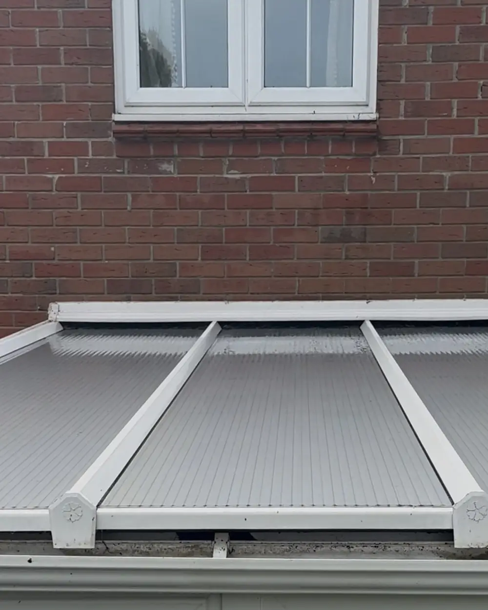 After: the same conservatory roof clean, its panels and glazing bars white